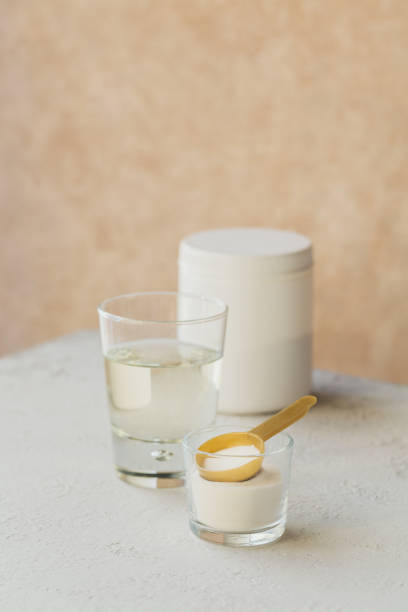 istock Glass with collagen dissolved in water and collagen protein powder on a light beige table. Healthy lifestyle concept. 1319732526