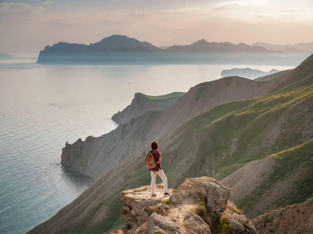 istock A young Asian woman with a backpack hiking in the summer. 1319736748