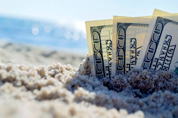 Three dollar bills are buried in sand on sandy beach near sea on sunny Three dollar bills are buried in sand on sandy beach near sea on sunny bright summer day close-up. Money grows in sand. Dollars buried in ground. Growing money in sand. One hundred dollar bill money. antiquities stock pictures, royalty-free photos & images
