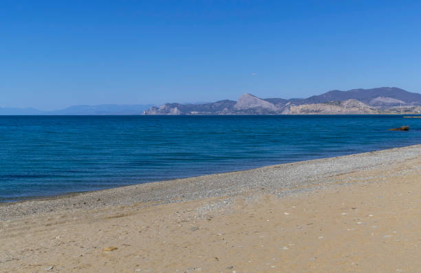 mar tranquilo y playa de arena vacía en kapsel bay. crimea. - out of season fotografías e imágenes de stock