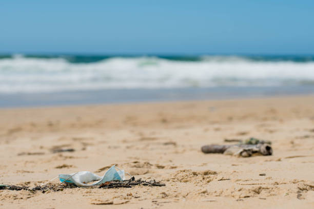 istock protective face mask thrown on the beach close-up 1319740642