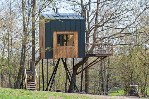 Nova Bana, Slovakia - April 25, 2021 : Modern wooden tree house in the forest in the early spring.