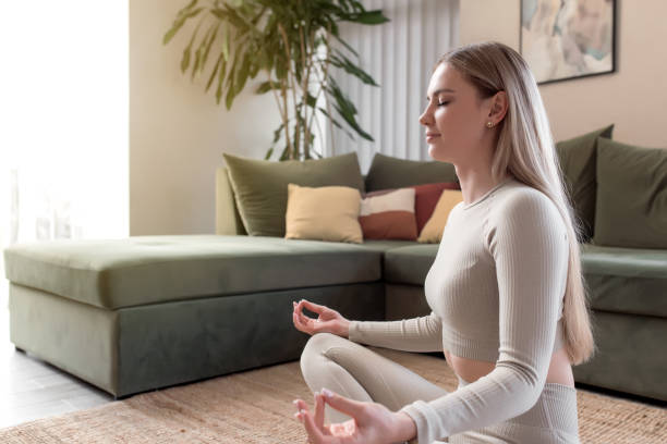 conceito de estilo de vida saudável com menina fazendo yoga em casa - lotus position - fotografias e filmes do acervo