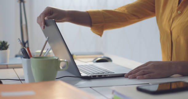 istock Woman sitting at desk and using her laptop 1319744362