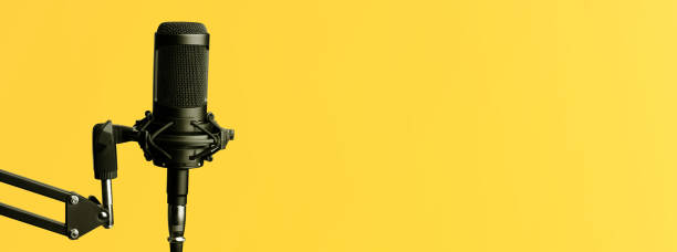 istock Studio condenser microphone, on Yellow background.Design of standard horizontal web banners with space for text 1319744375