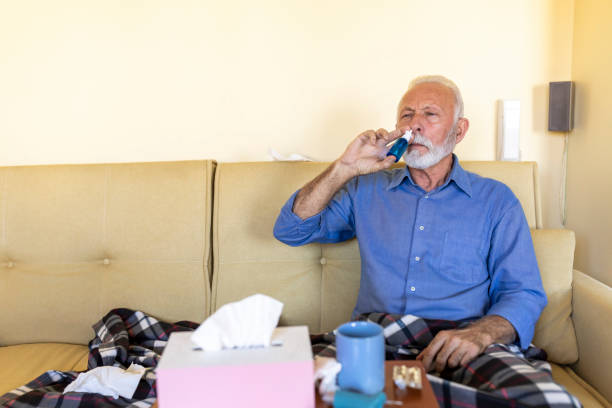 istock Ill Senior Man With a Seasonal Flu Virus or Sinusitis is Using Nasal Spray. 1319745159