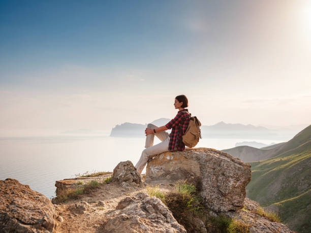 istock A young Asian woman with a backpack hiking in the summer. 1319745733