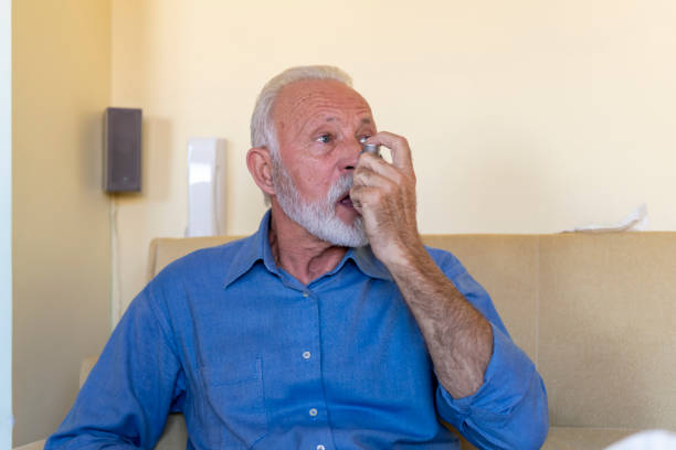 istock Photo of a Sick Older Man in the Bed with Asthmatic Problems. 1319746375