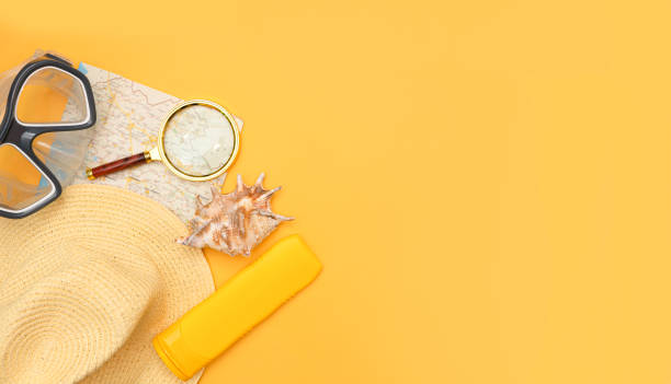 istock Swimming mask, hat, map, magnifier, sunblock and shell on a yellow background. 1319747049