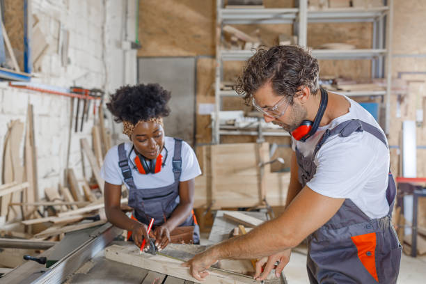 istock A Carpentry Workers are Working in Large Workshop Using a Measuring Tape to Mark the Wooden Plank. 1319747613