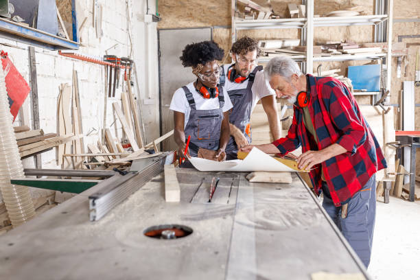 istock Multicultural Group of Carpenters are Studying Blueprints for the Work. 1319748355