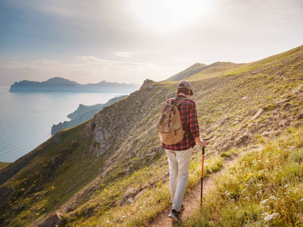 istock A young Asian woman with a backpack hiking in the summer. 1319748574