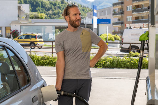 Young man refuelling his car at a gas station