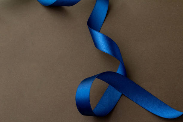 Image of gift with bright blue ribbon and dark brown background stock photo