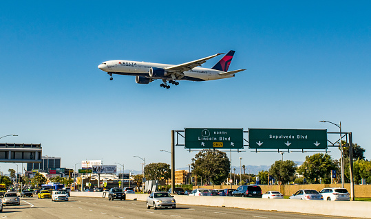 A Delta Air Lines Boeing 777 flies over the Pacific Coast Highway moments before touchdown onto Runway 27R at Los Angeles International Airport (LAX) on May 21, 2017
