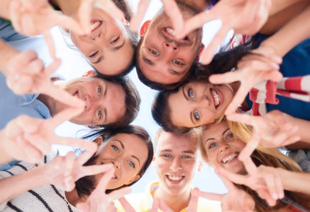 istock smiling friends in circle on summer beach 1319755972