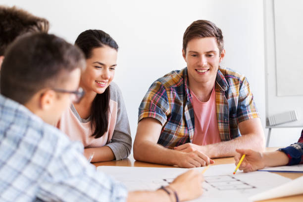 istock group of smiling students with blueprint 1319756997