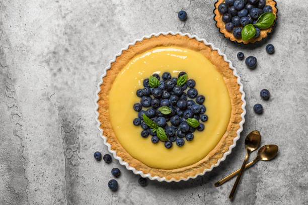 istock Lemon curd and blueberry tart on grey stone table. Top view. 1319757371