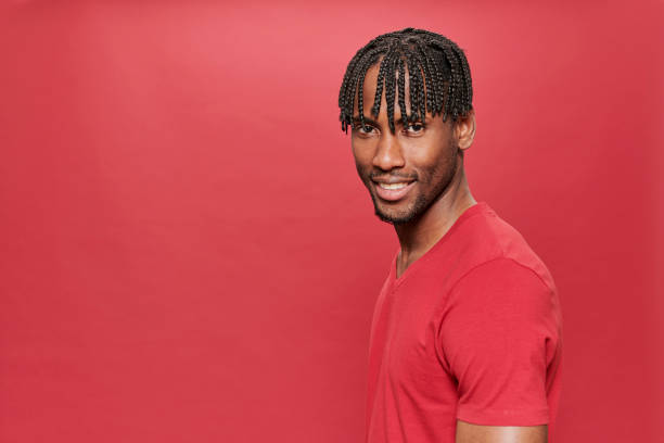 istock Smiling black man with red t-shirt looking at camera on red background 1319757428