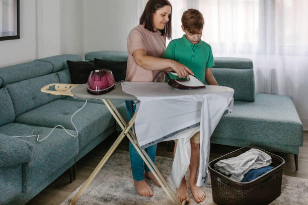 어머니 가르치 그녀의 비탄 아들 에 철 - iron women ironing board stereotypical housewife 뉴스 사진 이미지