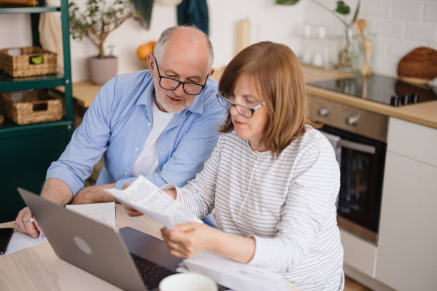 istock Senior couple sitting at kitchen table doing taxes and paying utility bils 1319759565