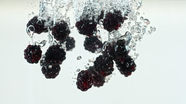 SLO MO LD Blackberries falling into the water