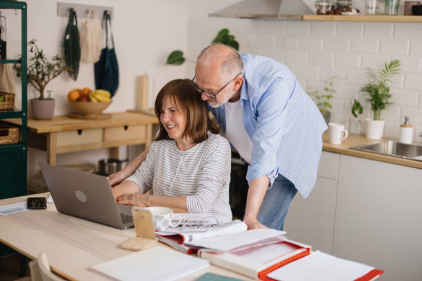 istock Mature couple calculates home finances sitting at kitchen table 1319759657