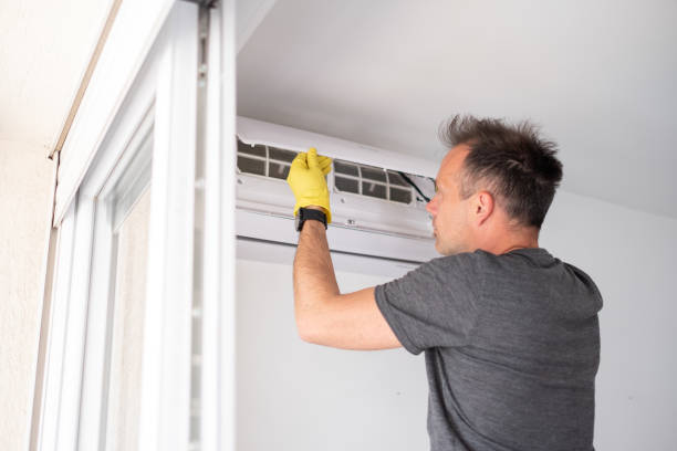 istock man in yellow gloves opening air conditioner 1319759861