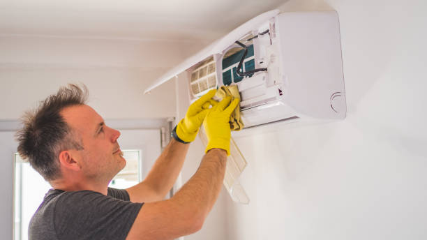 istock technician smiling and cleaning the air conditioner indoors 1319761268