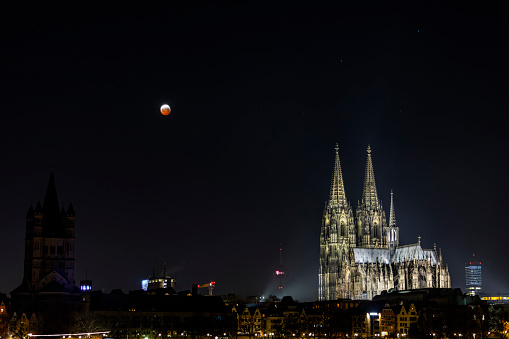 Full lunar eclipse over the skyline and the famous cathedral of Cologne. (Kölner Dom). Lunar eclipse so-called 'blood moon'. Germany