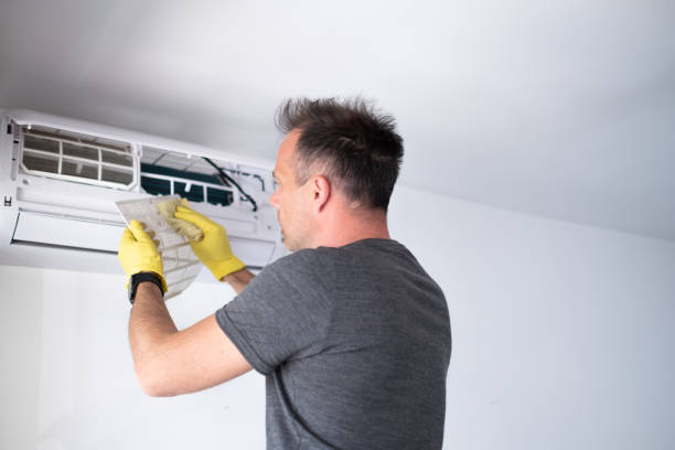 istock Young handsome man removing air filter from air conditioner 1319761981