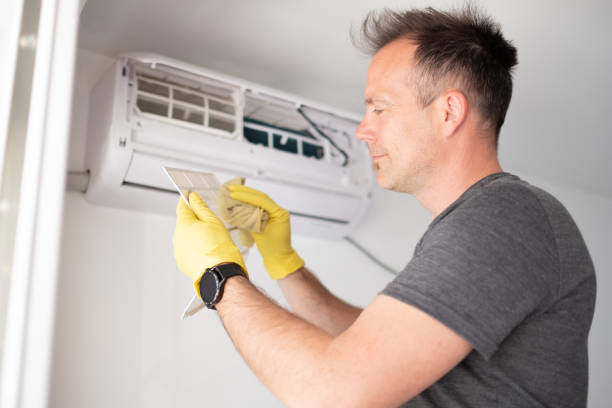 istock Man smiling and cleaning air filter 1319762069