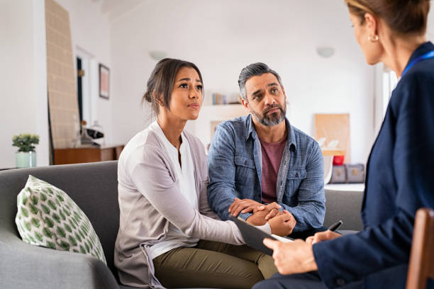 worried couple meeting social counselor - multiracial woman imagens e fotografias de stock