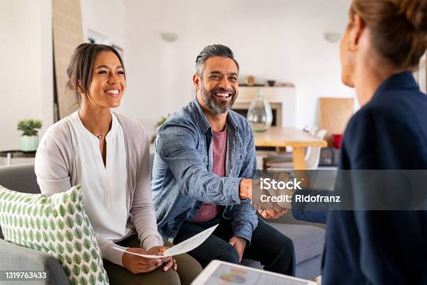 Multiethnic Couple Handshake With Consultant At Home Stock Photo - Download Image Now