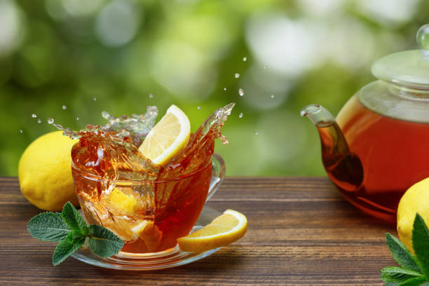 istock slice of lemon falling in glass cup of tea with splash 1319763769