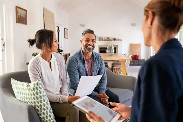 Photo of Couple talking to financial advisor at home