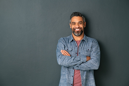 istock Smiling mixed race mature man on grey background 1319763895