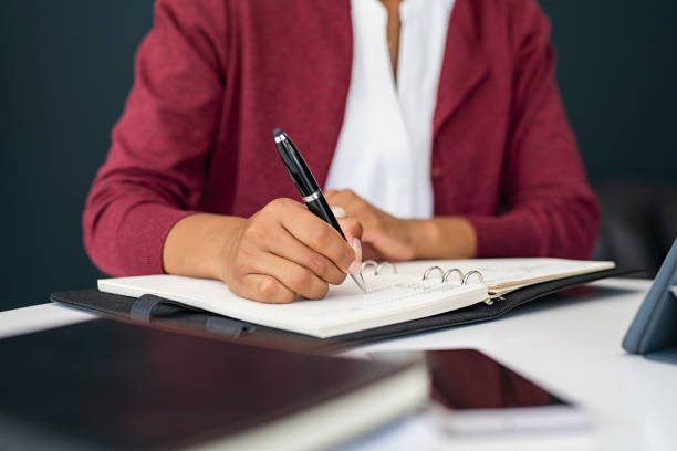 istock Black woman hands writing on agenda while working 1319763897