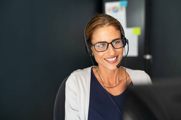 agente di call center maturo che lavora da casa - smiling women glasses assistance foto e immagini stock