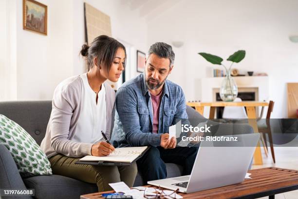 Mid Adult Couple Working On Home Finance Stock Photo - Download Image Now - Finance, Couple - Relationship, Home Finances