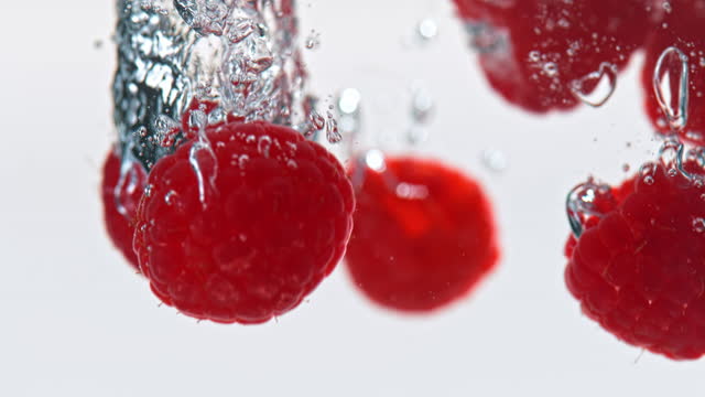 SLO MO LD Raspberries falling into water