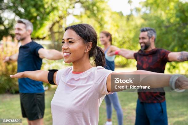 Mixed Race Woman Exercising In Park With Mature Friends Stock Photo - Download Image Now