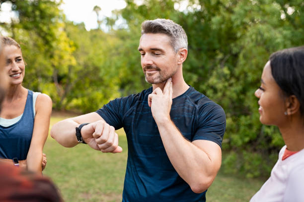 homme vérifiant la fréquence cardiaque au stationnement après forme cardio - taking pulse photos et images de collection