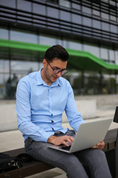 istock Business man using laptop while sitting on the bench. stock photo 1319770670