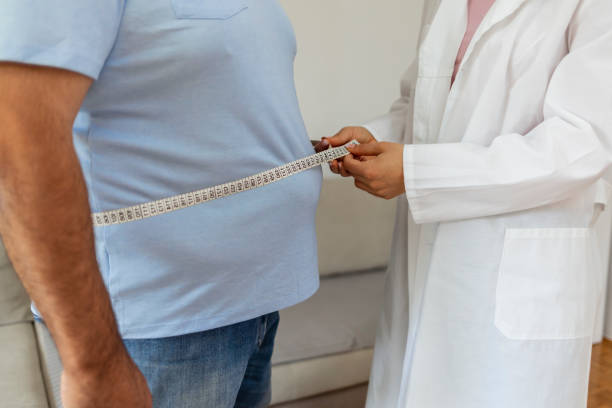 tiro cortado de uma médica do sexo feminino tomando medidas de gordura corporal de paciente obesa. - overweight dieting men unhealthy eating - fotografias e filmes do acervo