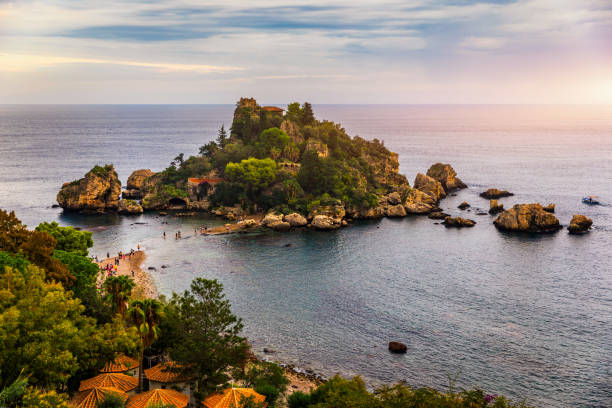 Aerial view of Isola Bella in Taormina, Sicily, Italy. Isola Bella is small island near Taormina, Sicily, Italy. Narrow path connects island to mainland Taormina beach in azure waters of Ionian Sea. Aerial view of Isola Bella in Taormina, Sicily, Italy. Isola Bella is small island near Taormina, Sicily, Italy. Narrow path connects island to mainland Taormina beach in azure waters of Ionian Sea. giardini naxos stock pictures, royalty-free photos & images