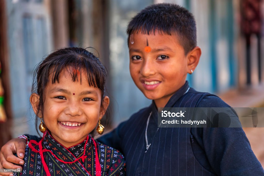 Portrait of Nepali children wearing traditional clothes, Bhaktapur, Nepal Nepali children wearing traditional Newari clothes going to the festival in an ancient town of Bhaktapur. Bhaktapur is an ancient town in the Kathmandu Valley and is listed as a World Heritage Site by UNESCO for its rich culture, temples, and wood, metal and stone artwork. Kathmandu Stock Photo