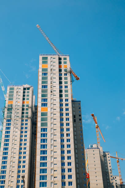 istock Modern apartment building with crane on construction site 1319774582