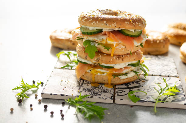 istock Fresh healthy sandwiches with seeded bagel, mayo, salmon, egg, cucumber and rocket on grey 1319776589