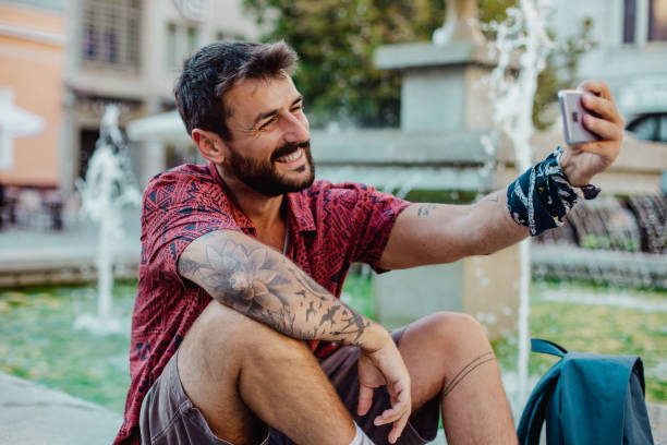 istock Tattooed young man uses a phone 1319777910